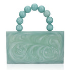 Green resin clutch with velvet lining, heavy-duty sling, and extra pocket for stylish storage.
