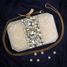Salmon resin clutch with stone embellishments, soft lining, and extra pocket for practical storage.
